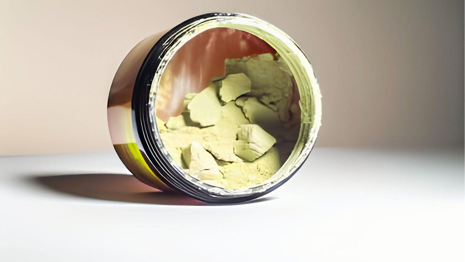 Open jar of expired pre workout powder with clumpy green chunks showing spoilage