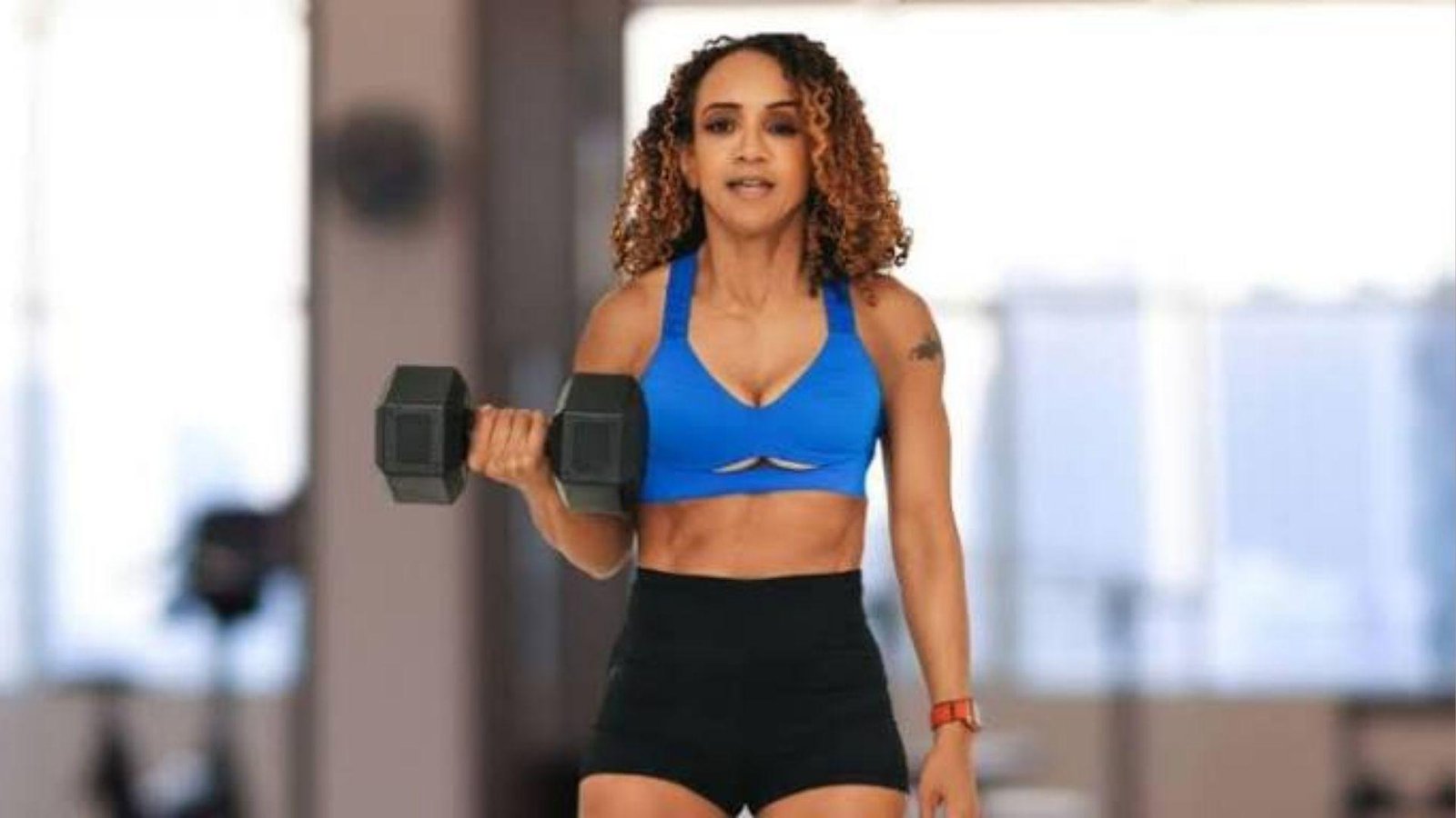 woman doing biceps curls with dumbbell.