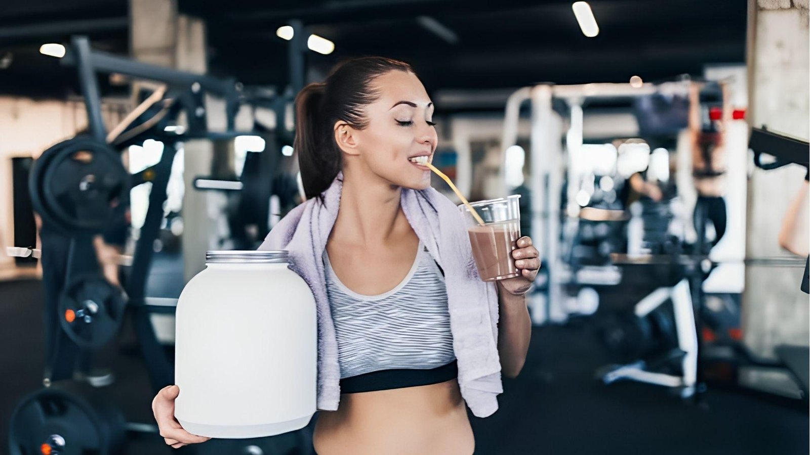 Woman in gym holding protein tub and drinking pre workout shake