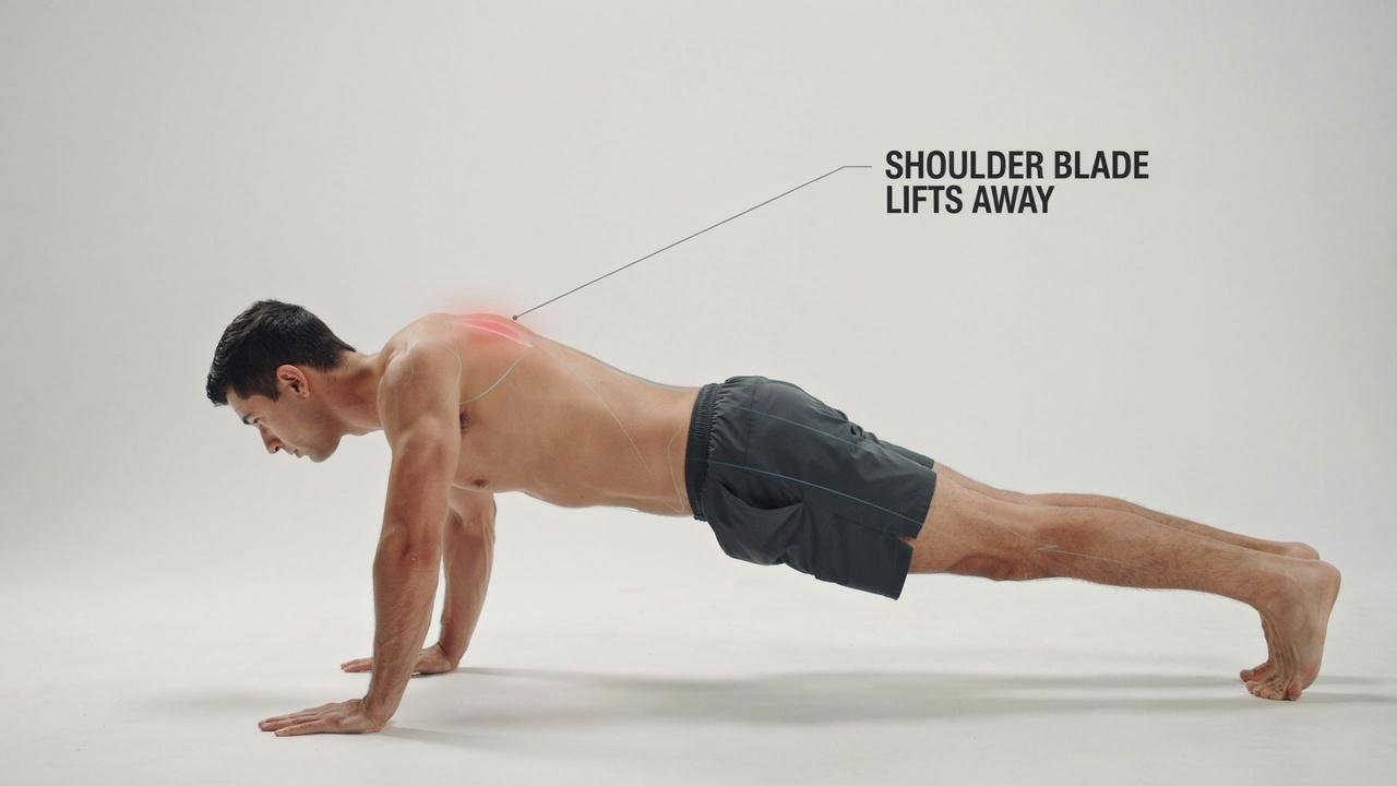 Man doing a push up with his shoulder blade lifting away from his back.