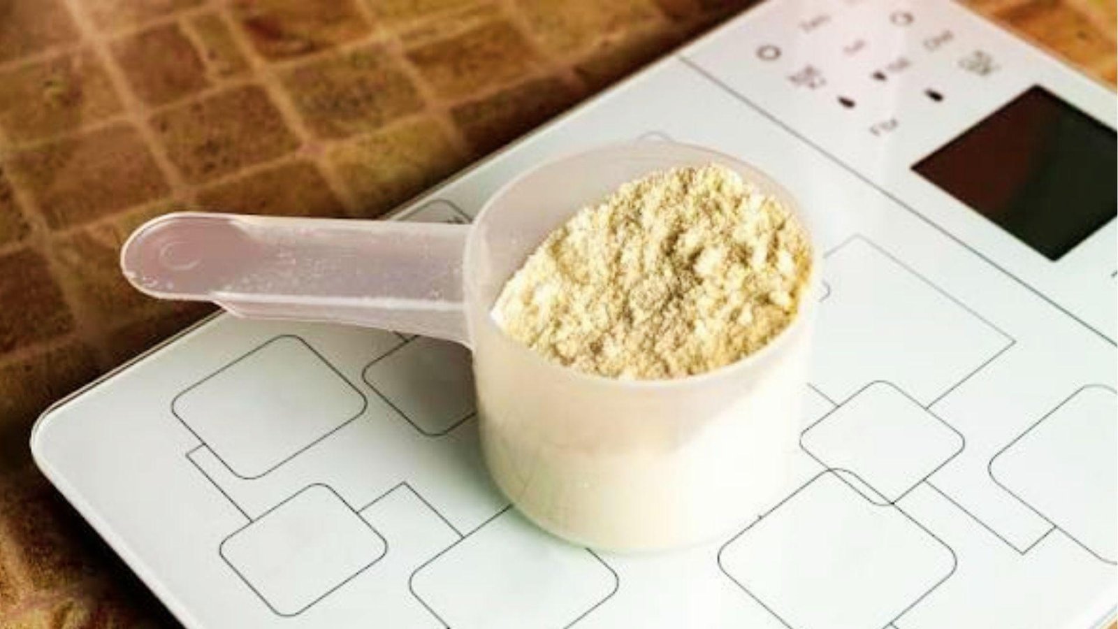 Scoop of fresh pre workout powder on digital scale for measuring supplement dose