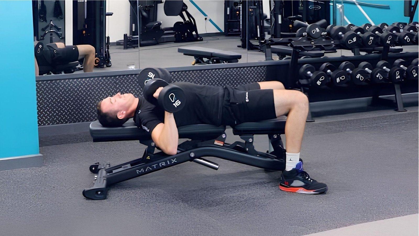 A person doing Dumbbell Bench Press in a gym