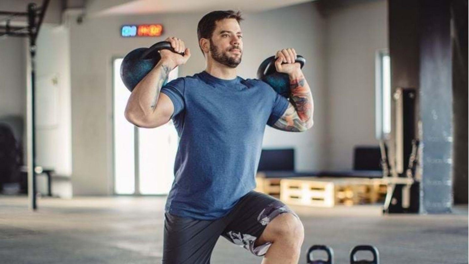 man lifting two kettlebells while doing lunges.