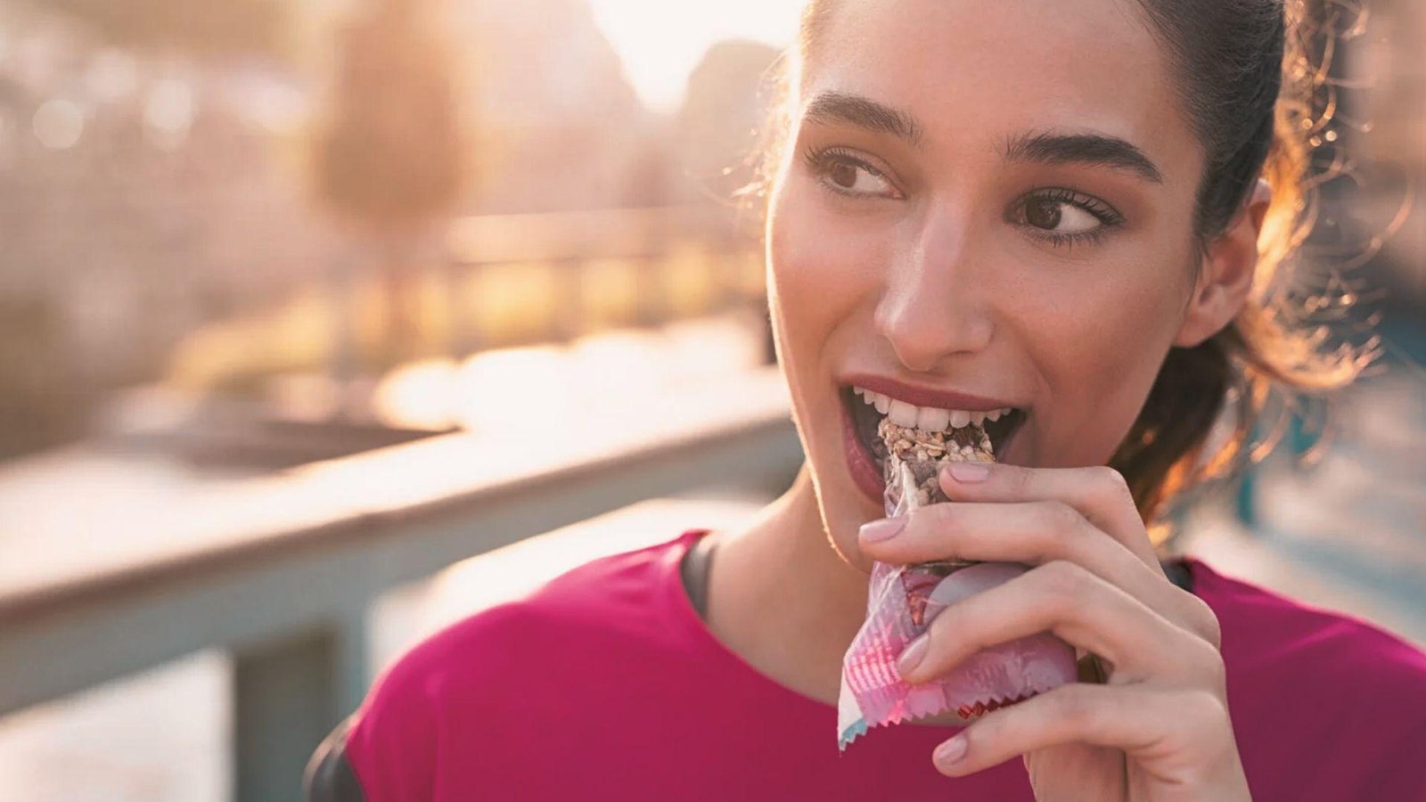 Person eating a protein bar exercising for energy.