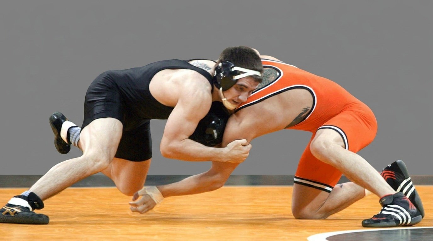 Wrestlers tackling each other mid wrestling match.
