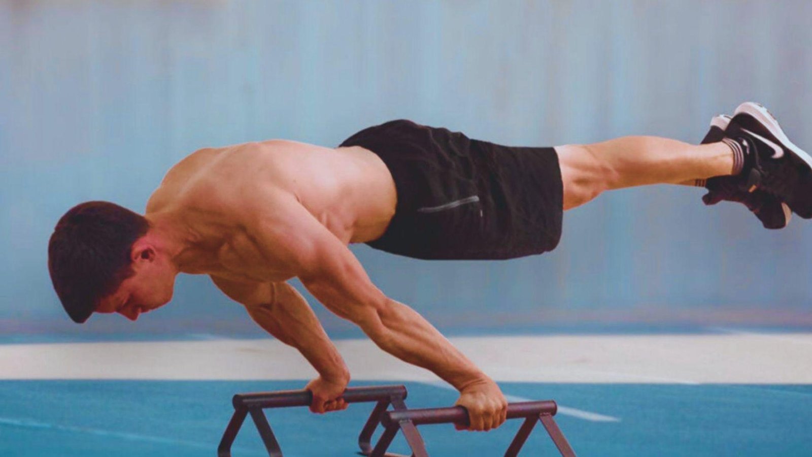 A man performing a push-up on a wooden platform, showcasing strength and fitness in an outdoor setting.